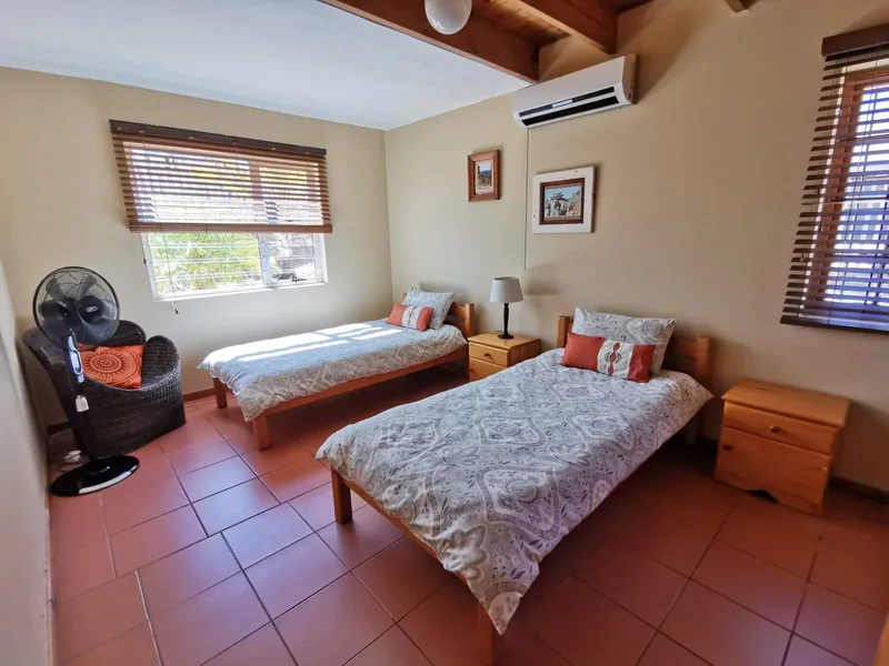 Downstairs twin bedroom with orange linen accents