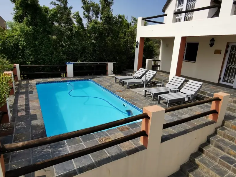 Exterior view of thatched house and pool